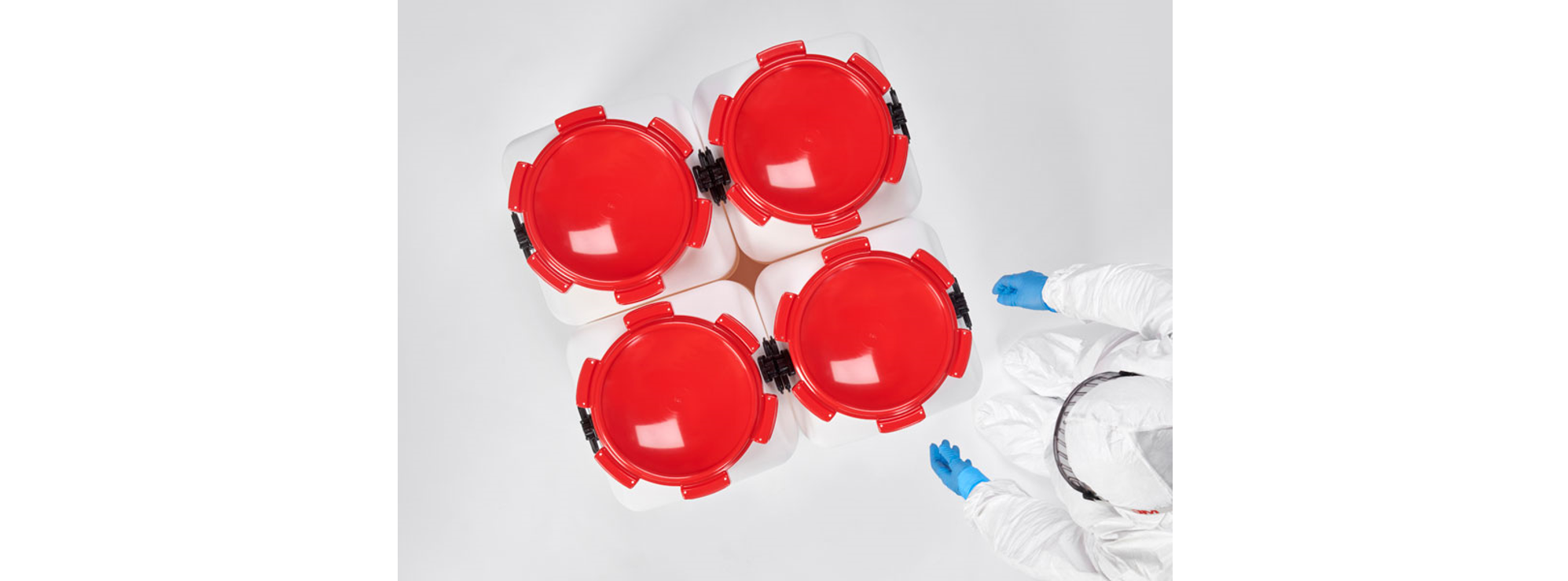 Multiple square HDPE drums with red marking in a production environment, demonstrating efficient handling